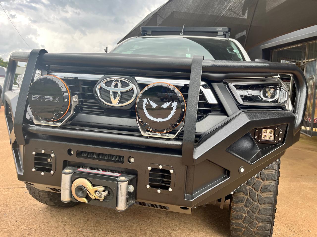 Hilux Expedition Ready 4x4 build showcase - Professional Hilux expedition build featuring Steady 7-inch spotlights, Onka replacement bumper, Rino Expedition canopy, and winch for ultimate adventure capability. by Audio Sat 4x4
